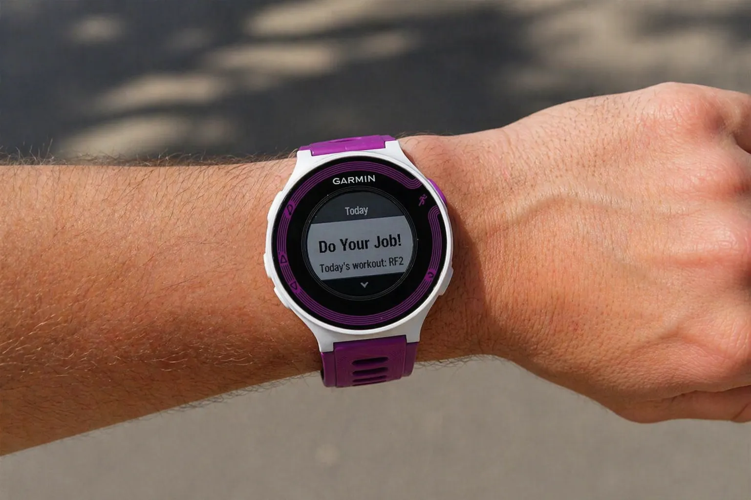 Garmin Forerunner watch on a wrist showing a workout prompt: 'Do Your Job! Today's workout: RF2'.
